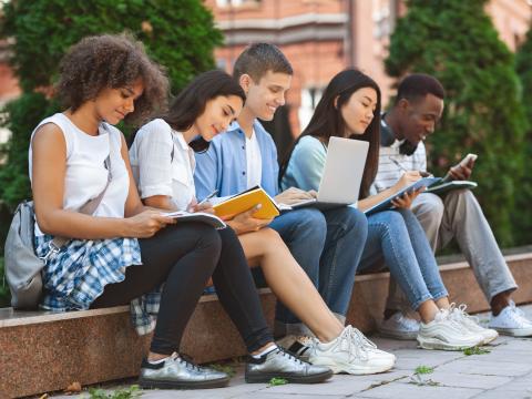 Six students studying together on a bench