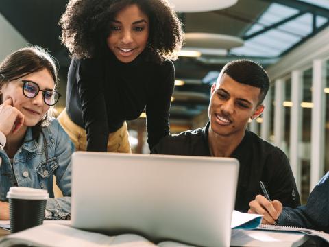 Four students in a group study together on a computer.