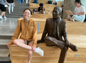 A student poses next to a statue during the HBCU tour.